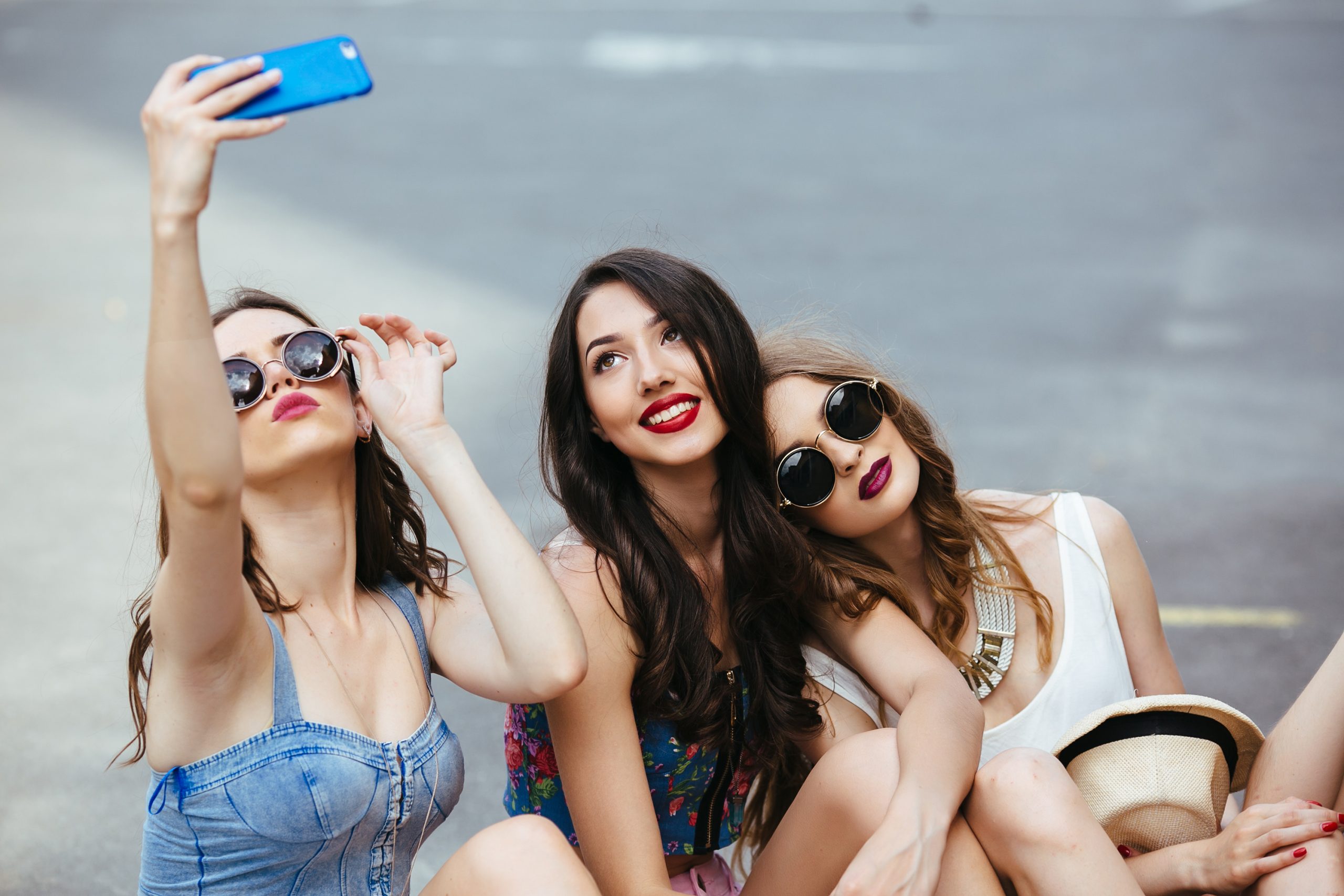Three beautiful young girls on the street take photos